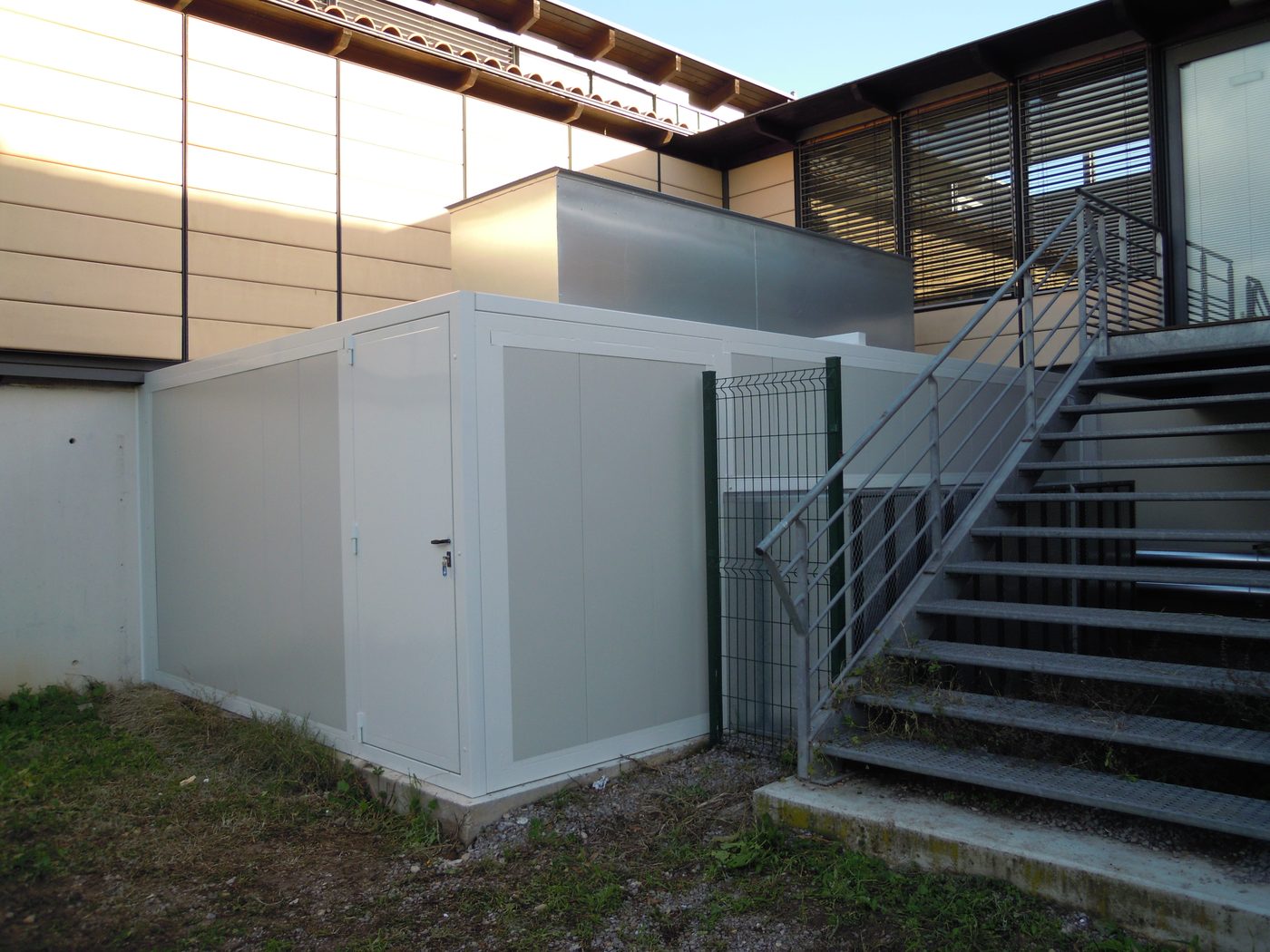Capotage acoustique de pompe à chaleur installé au pied d'un bâtiment, à proximité immédiate des fenêtres et des riverains